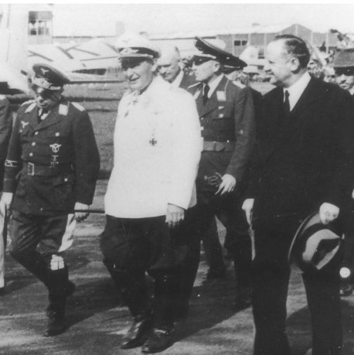 25 mei 1940: Göring bezoekt Schiphol, vergezeld door Duitse generaals. Rechts naast Göring (met hoed in de hand) Friedrich Seekatz, de nieuwe Duitse directeur van de fabriek. Geheel links Albert Plesman, directeur van de KLM. Eén van de drie heren op de twee of derde rij is vermoedelijk Reinhold Platz.