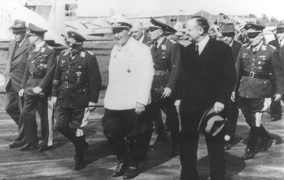 25 mei 1940: Göring bezoekt Schiphol, vergezeld door Duitse generaals. Rechts naast Göring (met hoed in de hand) Friedrich Seekatz, de nieuwe Duitse directeur van de fabriek. Geheel links Albert Plesman, directeur van de KLM. Eén van de drie heren op de twee of derde rij is vermoedelijk Reinhold Platz.