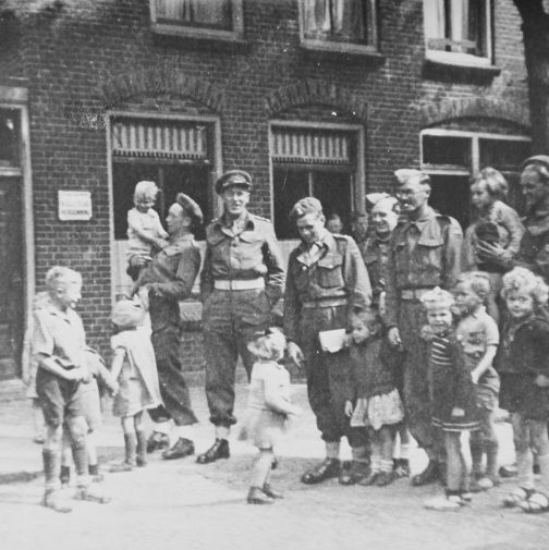 Vlielandse kinderen op de foto met zes Britse bevrijders voor het Café de Boer, 31 mei 1945.
