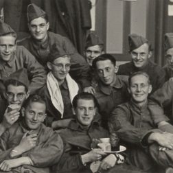 Groep militairen. De militair midden onder met bord is Toon Hunkemöller.